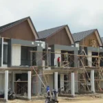 Ilustrasi rumah dalam tahap pembangunan yang mangkrak dengan spanduk protes pembeli
